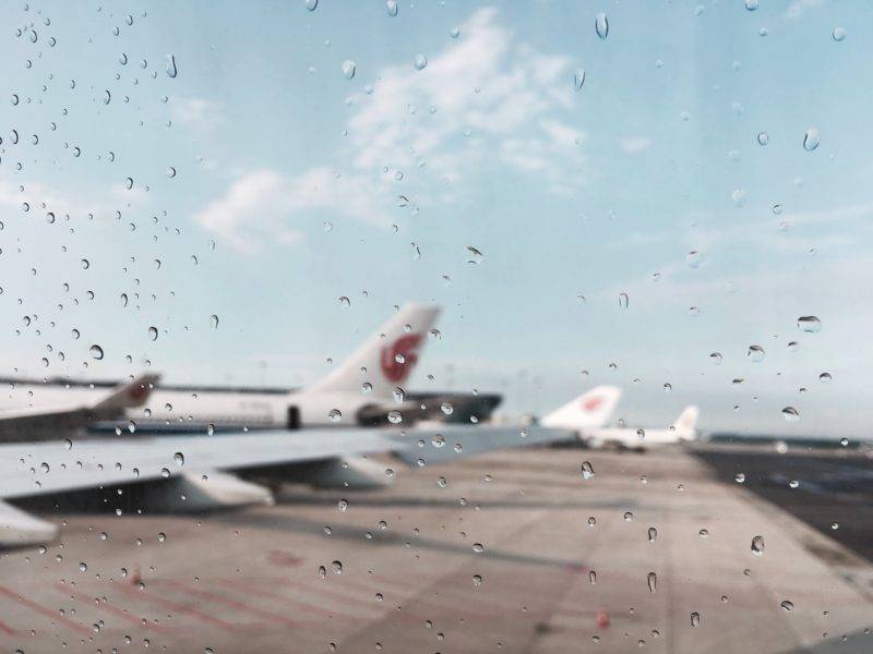 window with rain drops and some airplanes in the background